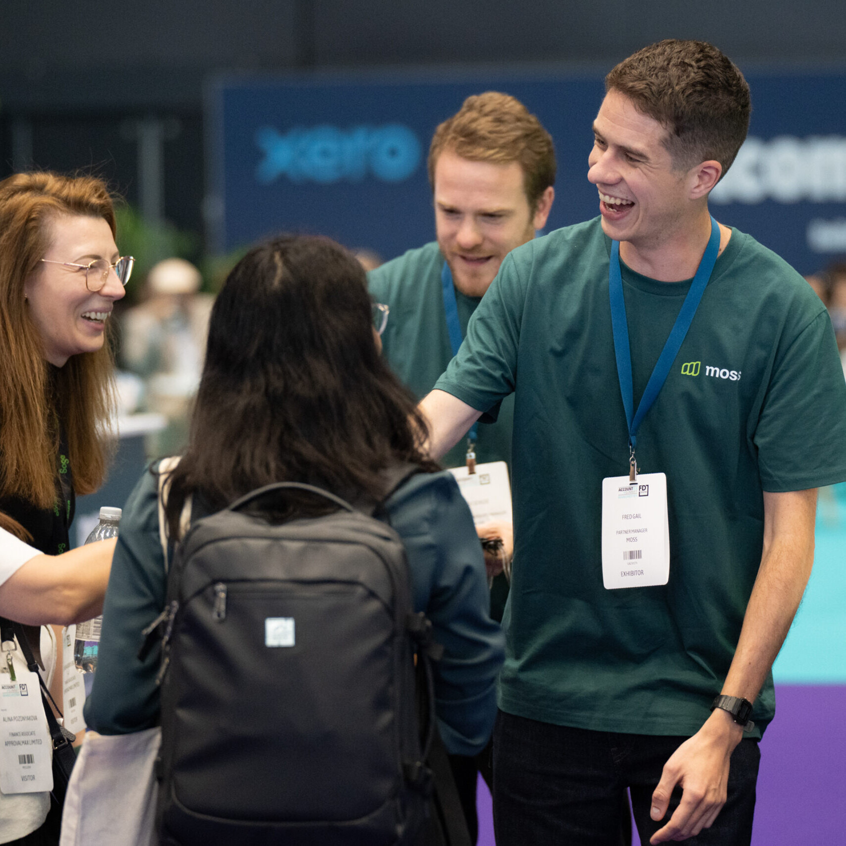 Male exhibitor shaking hands with female visitor with a smile