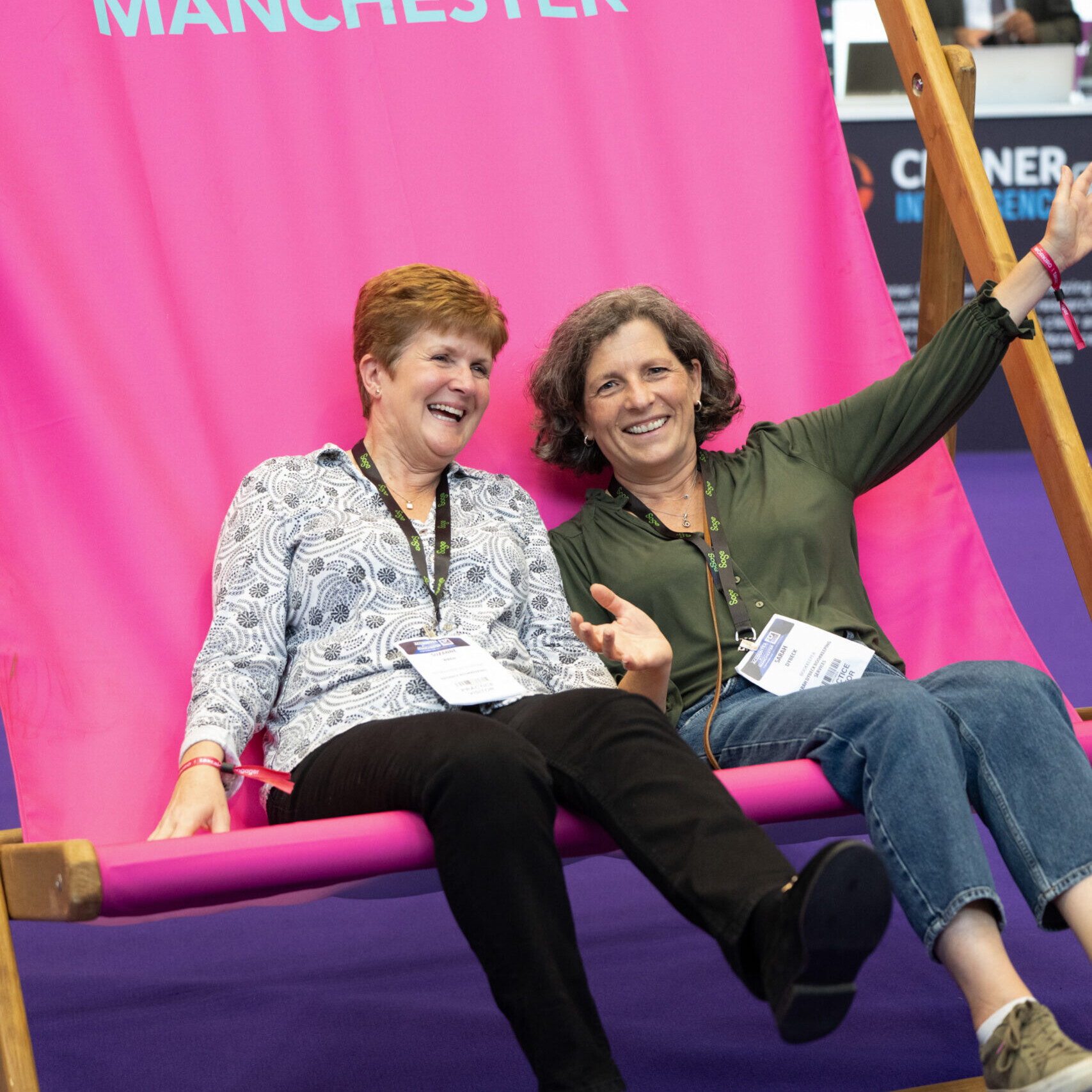 Two females posing for a photo on the Accountex Deck chair